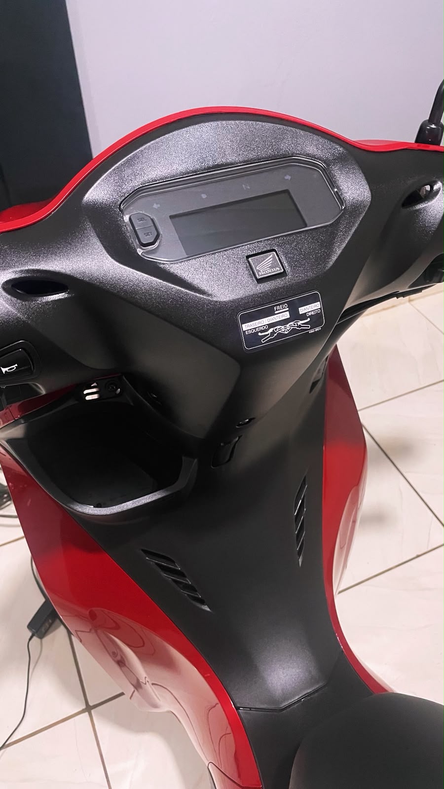 Plásticos e painel de uma moto vermelha com a superfície uniforme