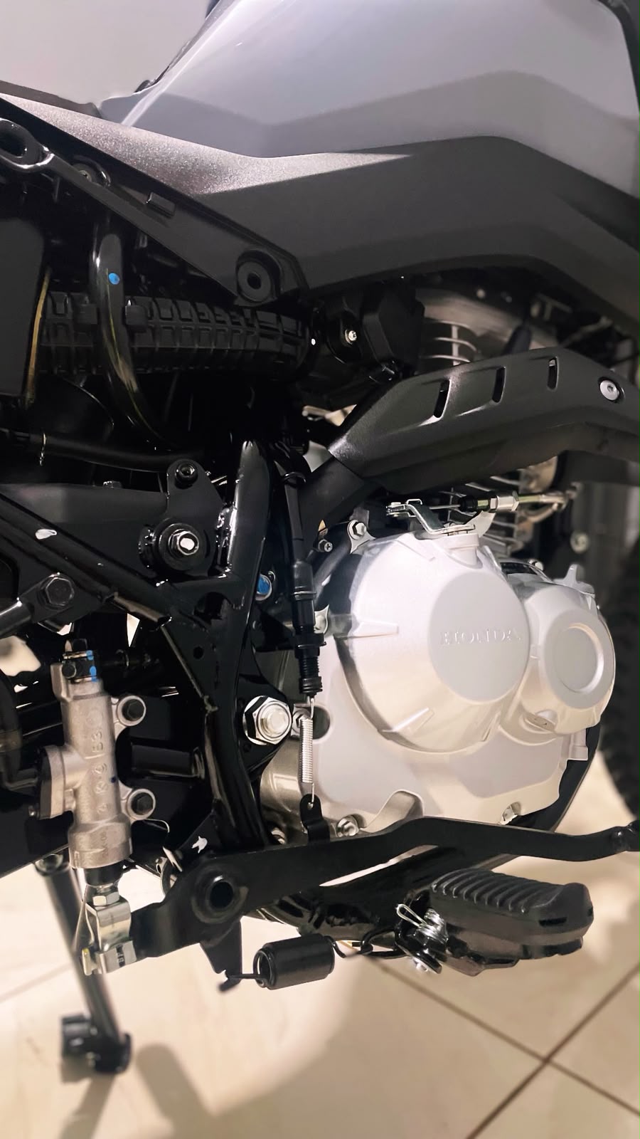 Detalhe do motor e do quadro de uma moto, com as peças limpas e sem manchas