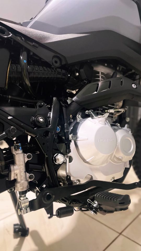 Detalhe do motor e do quadro de uma moto, com as peças limpas e sem manchas